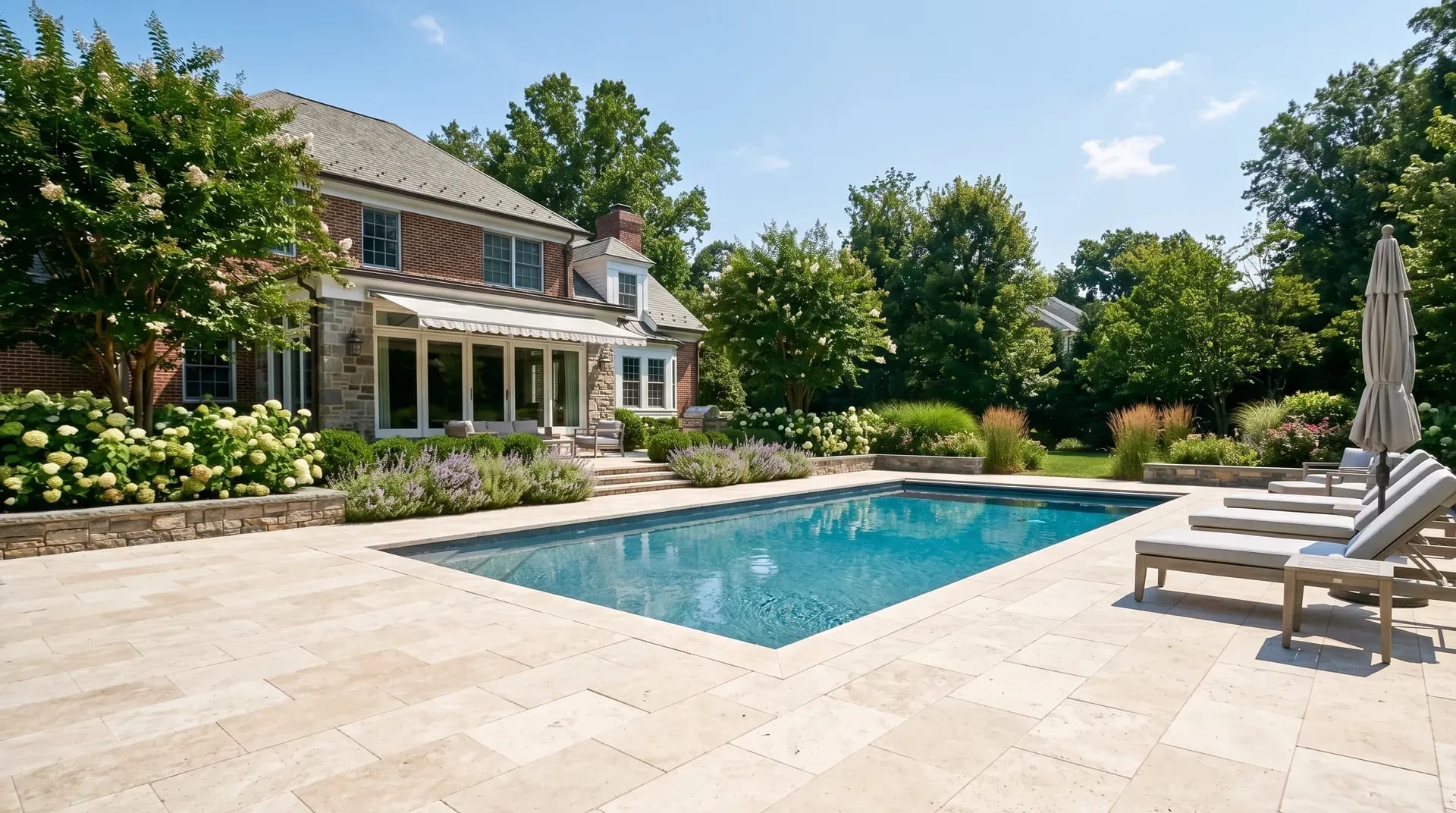 Restored travertine pool deck with clean joints around an inground pool