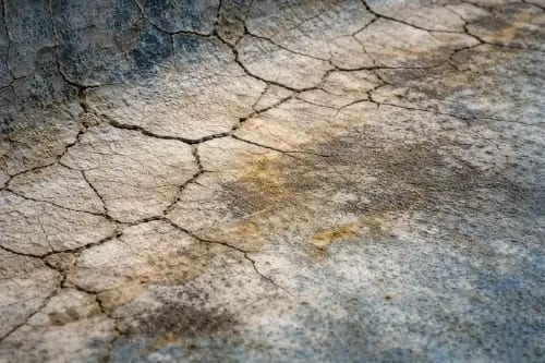 Close-up of severely cracked and stained aging pool plaster in need of resurfacing