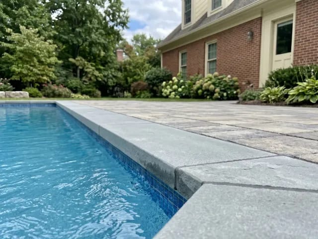New pool coping with clean sealed joints around clear water