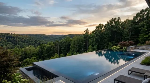 Infinity-edge pool with a vanishing water edge overlooking a wooded valley view