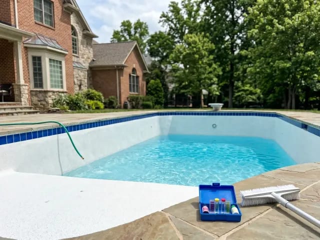 Freshly resurfaced pool refilling with startup test kit on the deck